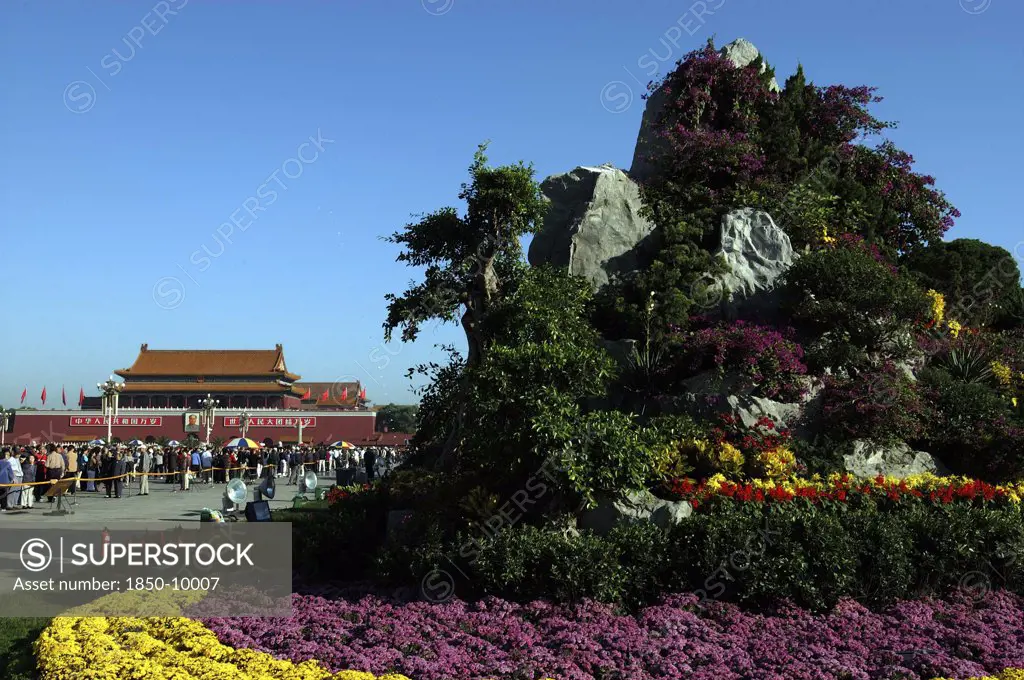 China, Beijing, Tiananmen Square, Gate Of Heavenly Peace Or Tiananmen. View Over Rockery And Flowerbeds Toward Crowds Gathered Outside The Gate Building