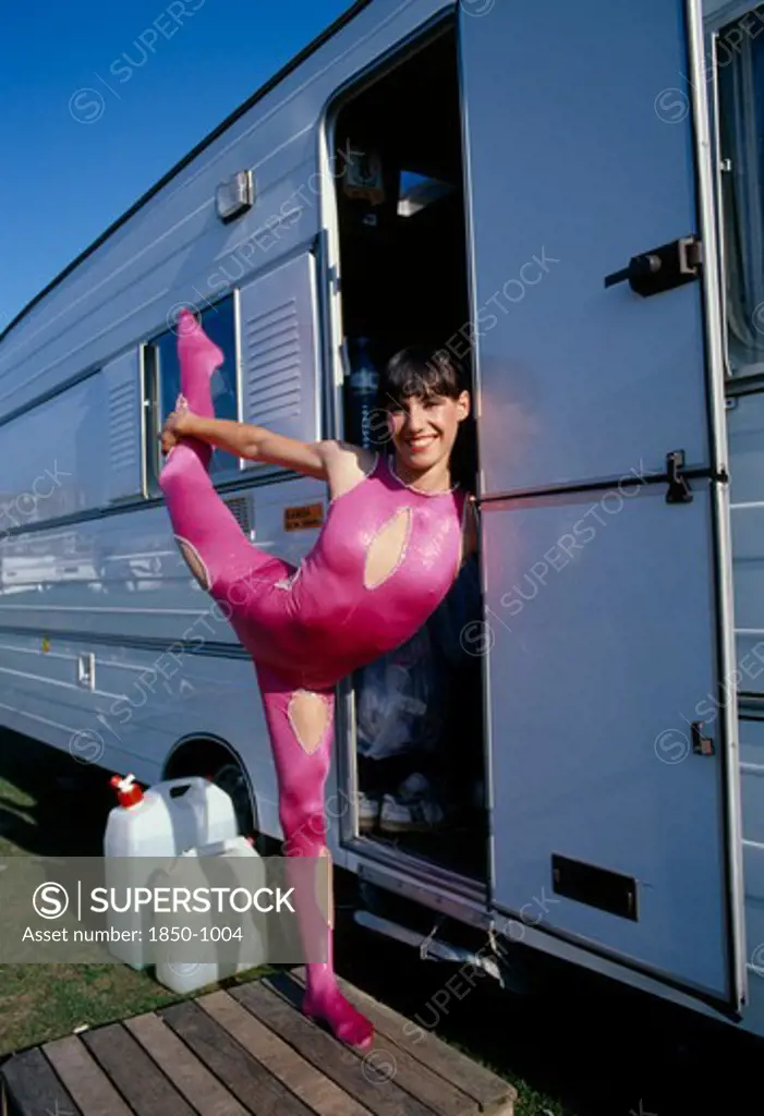 Entertainment, Circus, Acrobat, Female Acrobat In Pink Bodysuit In Arabesque Position In Doorway Of Caravan At Chipperfields Circus.
