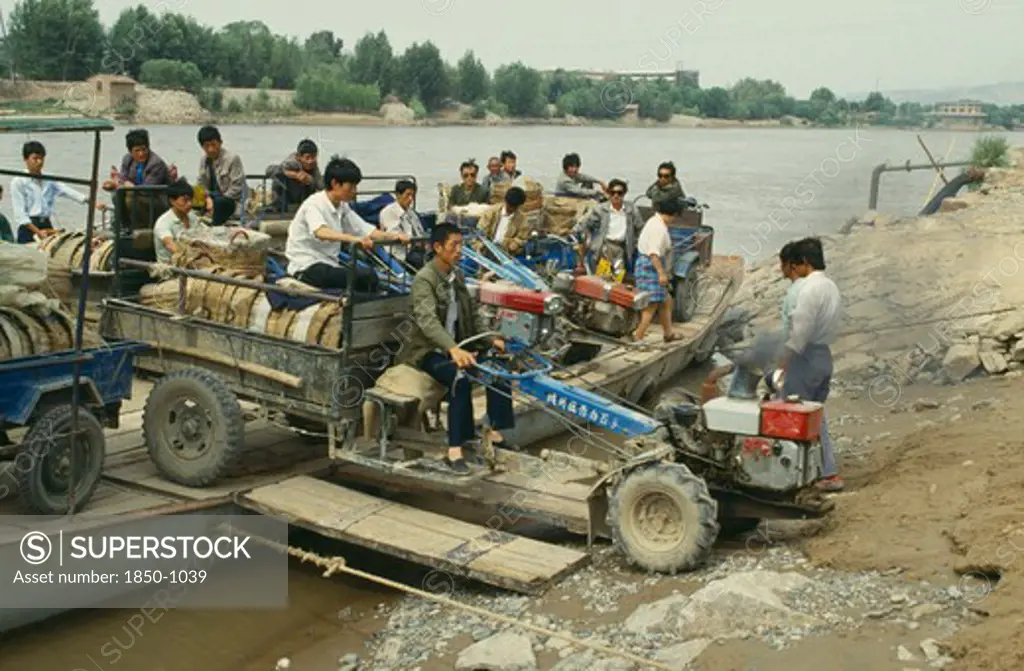 China, Yellow River, Men Taking A Tractor Off A Ferry