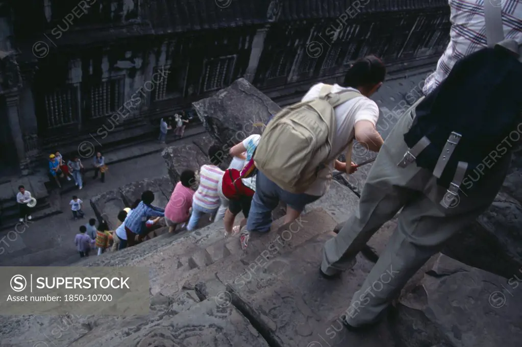 Cambodia, Siem Reap Province, Angkor Wat, Line Of Tourists Climbing Down Steep And Narrow Steps Of Tower In Upper Level.