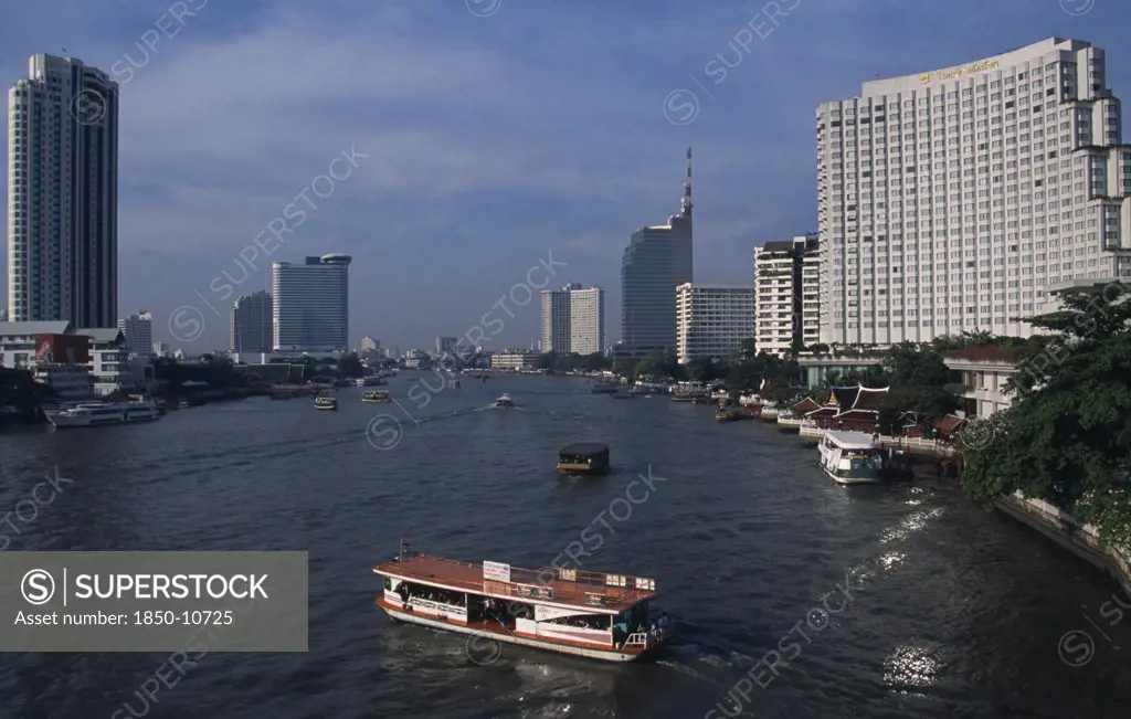 Thailand, South, Bangkok, The Shangri La Hotel On The Right The Peninsula Hotel On The Left Either Side Of The Chao Phraya River With A Cross River Ferry In The Foreground