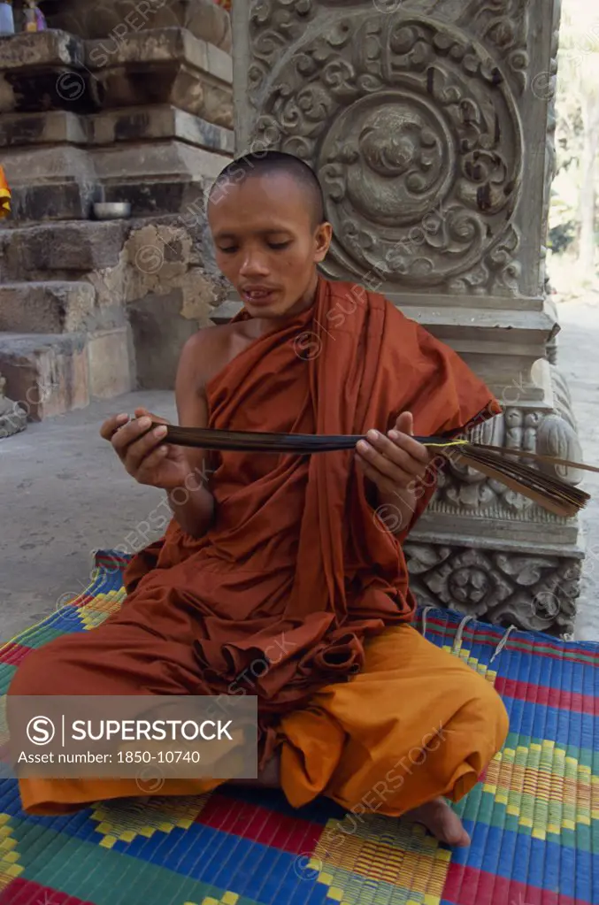 Cambodia, Siem Reap Province, Angkor Thom, Buddhist Monk Chanting From Sanskrit Prayers Inscribed On Palm Leaf.