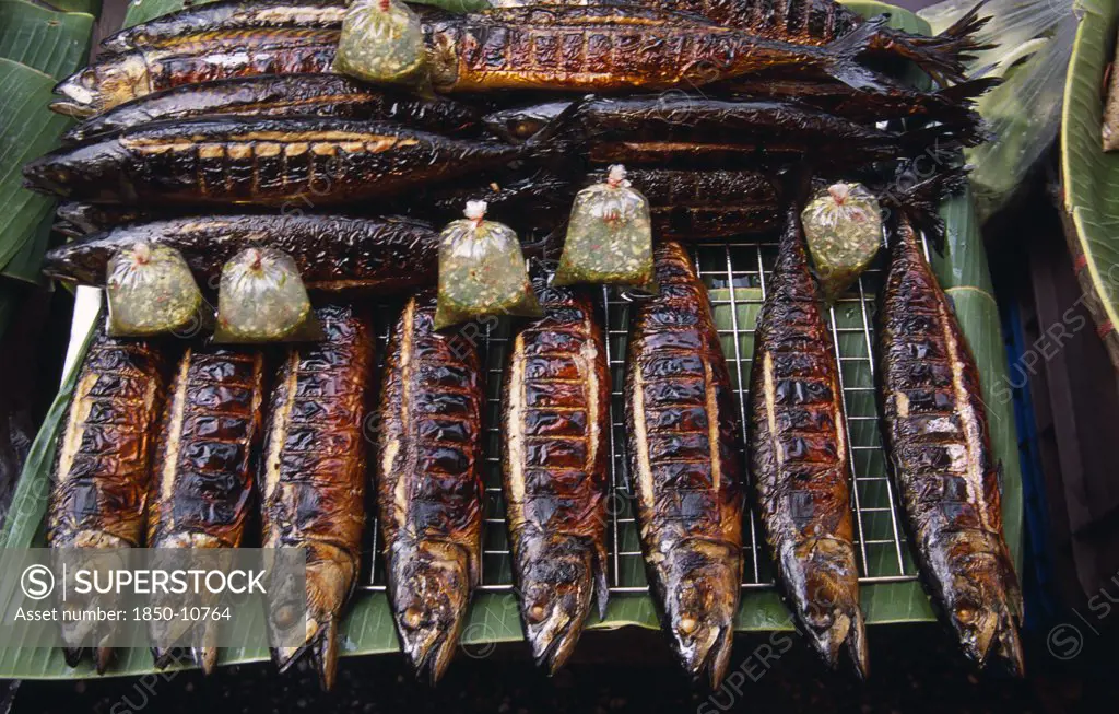 Thailand, North , Chiang Mai, Lam Yai Market.  Stall Displaying Grilled Fish And Bags Of Dipping Sauce For Sale.