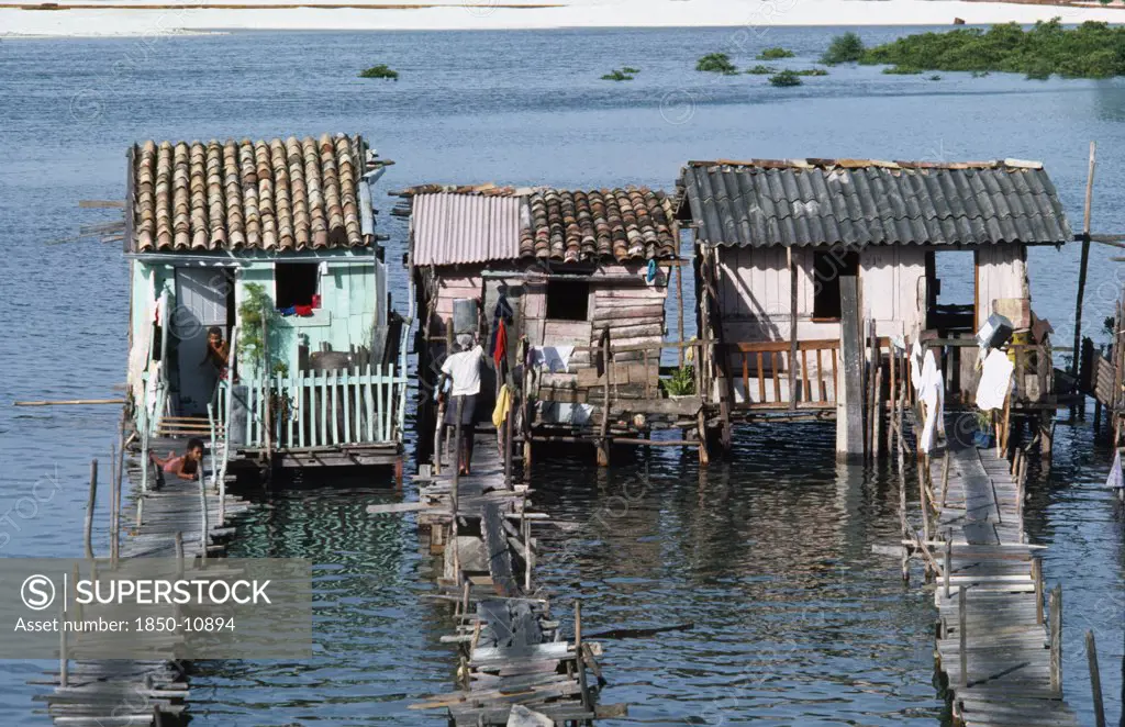 Brazil, Bahia, Salvador Da Bahia, Slum Dwellings Raised Above Sewage Polluted Water With Access By Wooden Bridge.