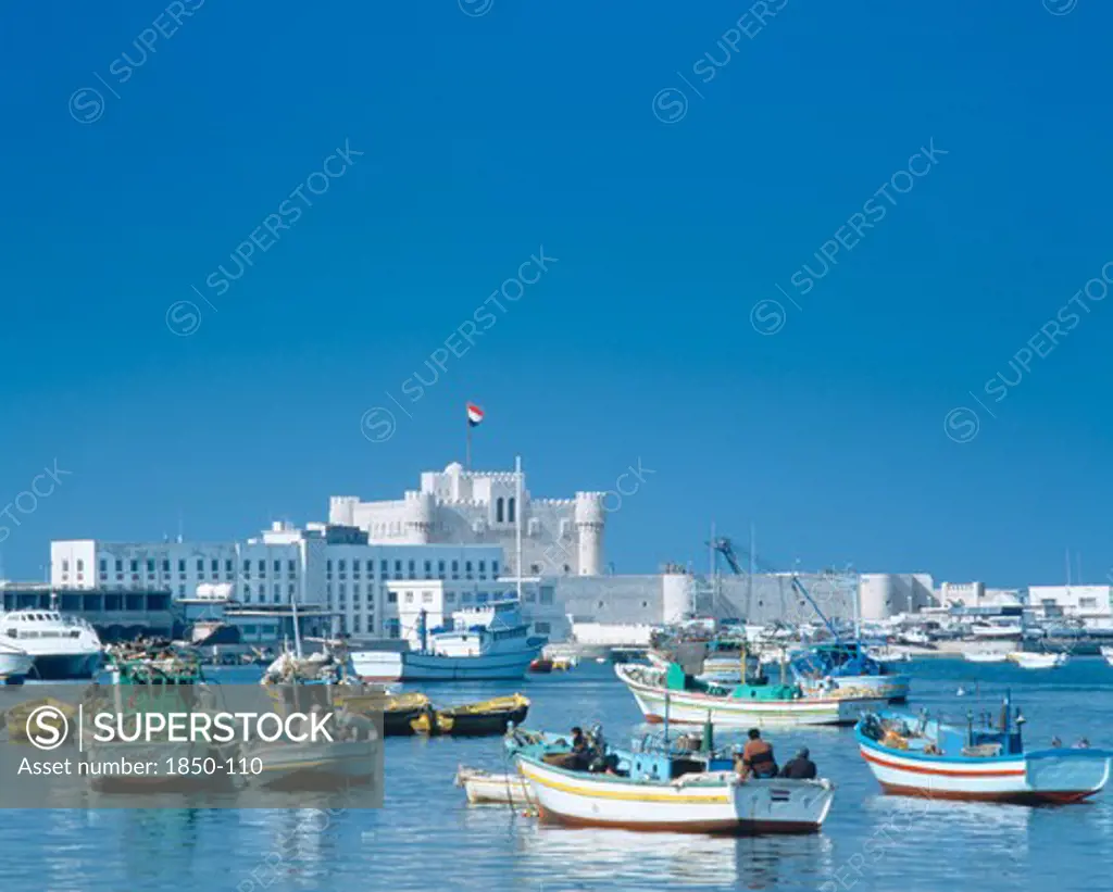 Egypt, Nile Delta, Alexandria, Fishing Boats Moored In Harbour With Fortress Castle And Walls Beyond.