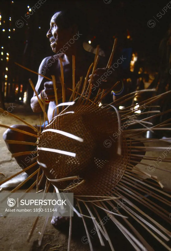 Colombia, Amazonas, Santa Isabel, Macuna Man Weaving Thin Wooden Strips To Make Basket.