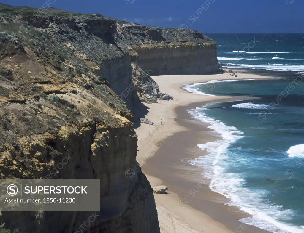 Australia, Victoria, Near Port Campbell, Great Ocean Road. View Along Rugged Rocky Cliffs And Sandy Beach