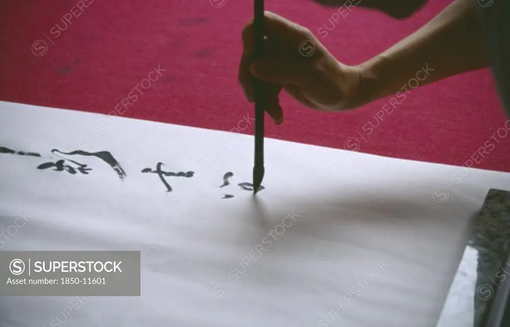 China, Sichuan, Leshan, Cropped View Of Person Writing Traditional Chinese Caligraphy.