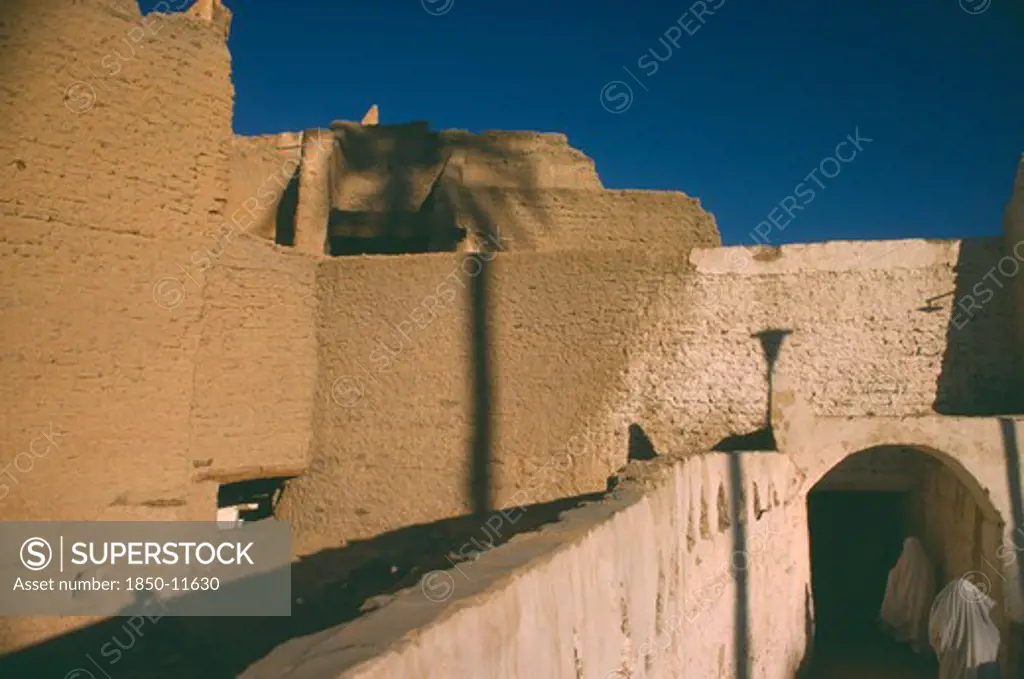 Libya, Ghadames Oasis, Veiled Women Walking Through Passage Below Mud Brick Town Walls