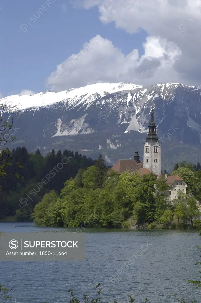 Slovenia, Lake Bled, View Over The Lake Toward Bled Island And The Church Of The Assumption With The Snow Capped Peaks Of The Julian Alps Behind