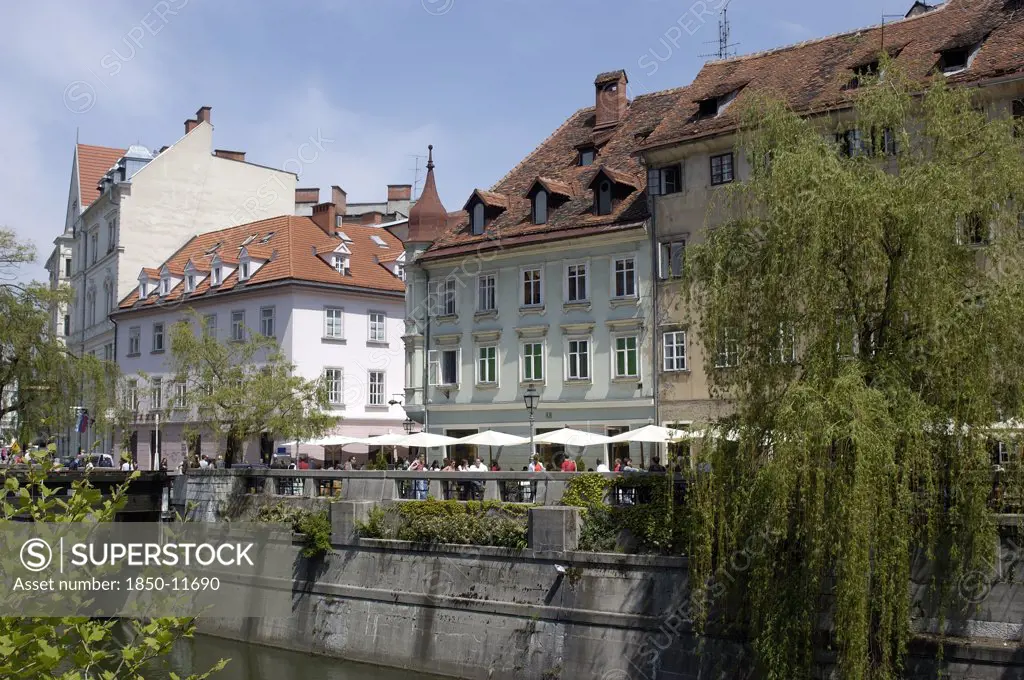Slovenia, Ljubljana, River Ljubljanica. View Along Row Of Riverside Cafes Toward The Old Town
