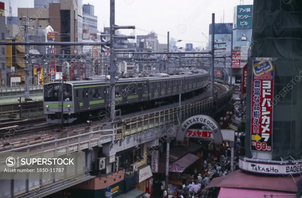 Japan, Honshu, Tokyo, Train Travelling Along The Elevated Tracks Above The Ameyayokocho Market Street