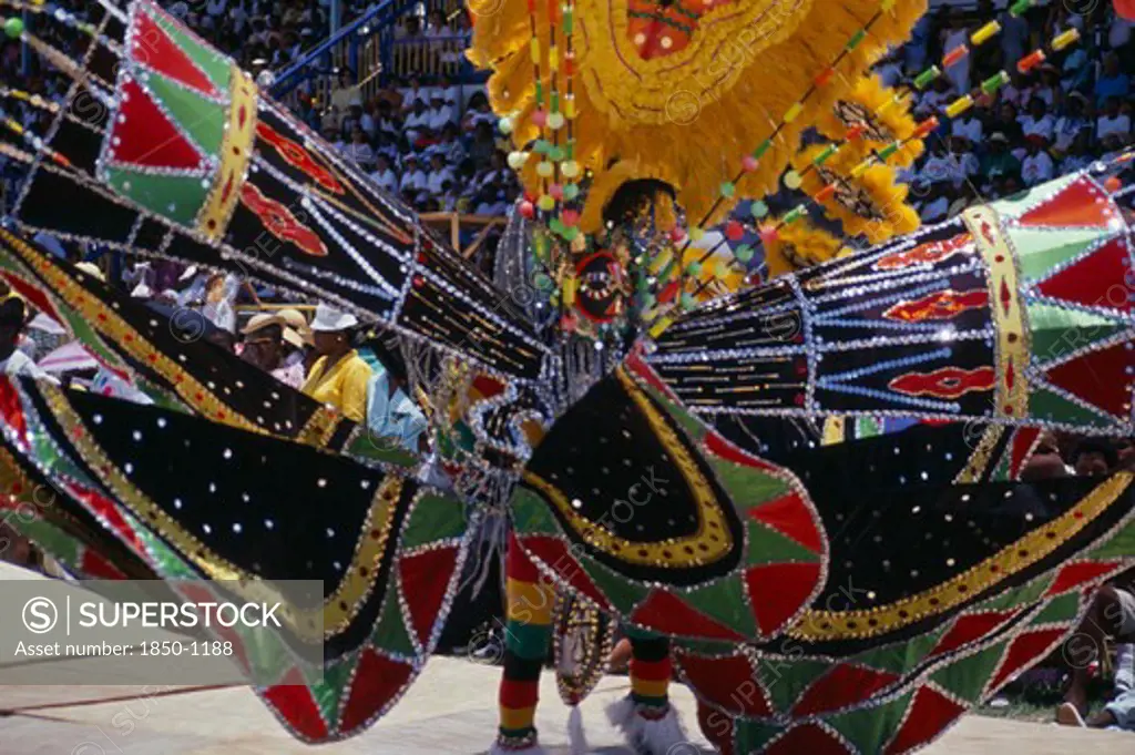 West Indies, Barbados, Festivals, 'Crop Over Sugar Cane Harvest Festival.  Grand Kadooment Carnival Parade Performer In Elaborate Black, Red, Yellow And Green Masked Costume.'