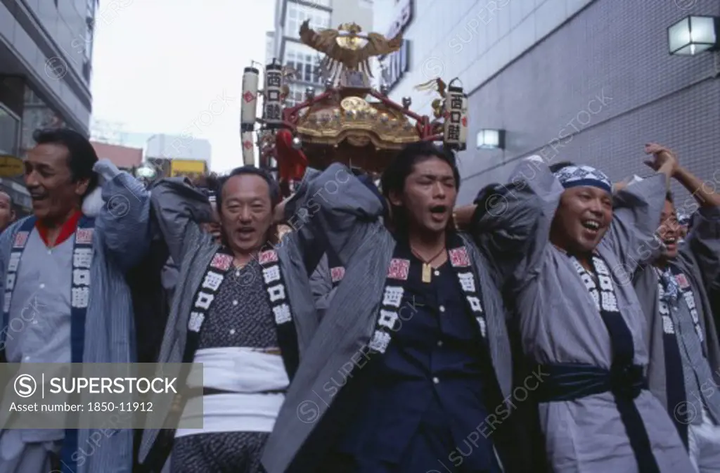 Japan, Honshu, Tokyo, Shinjuku. Men Carrying Mikoshi Throught The Street During A Festival Celebration