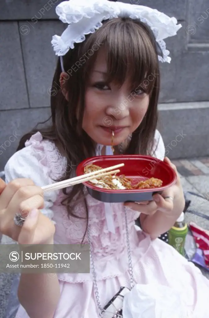 Japan, Honshu, Tokyo, Harajuku District. Portrait Of Young Teenage Girl Eating Noodles
