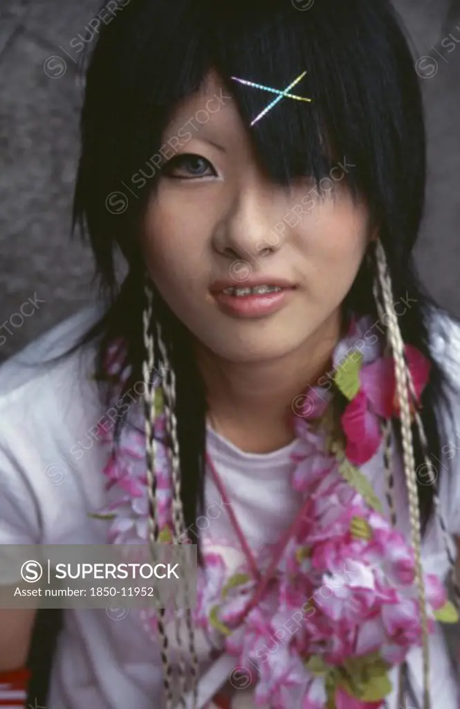 Japan, Honshu, Tokyo, Harajuku District. Portrait Of A Teenage Girl Wearing A Flower Garland And Sparkling Hairclips