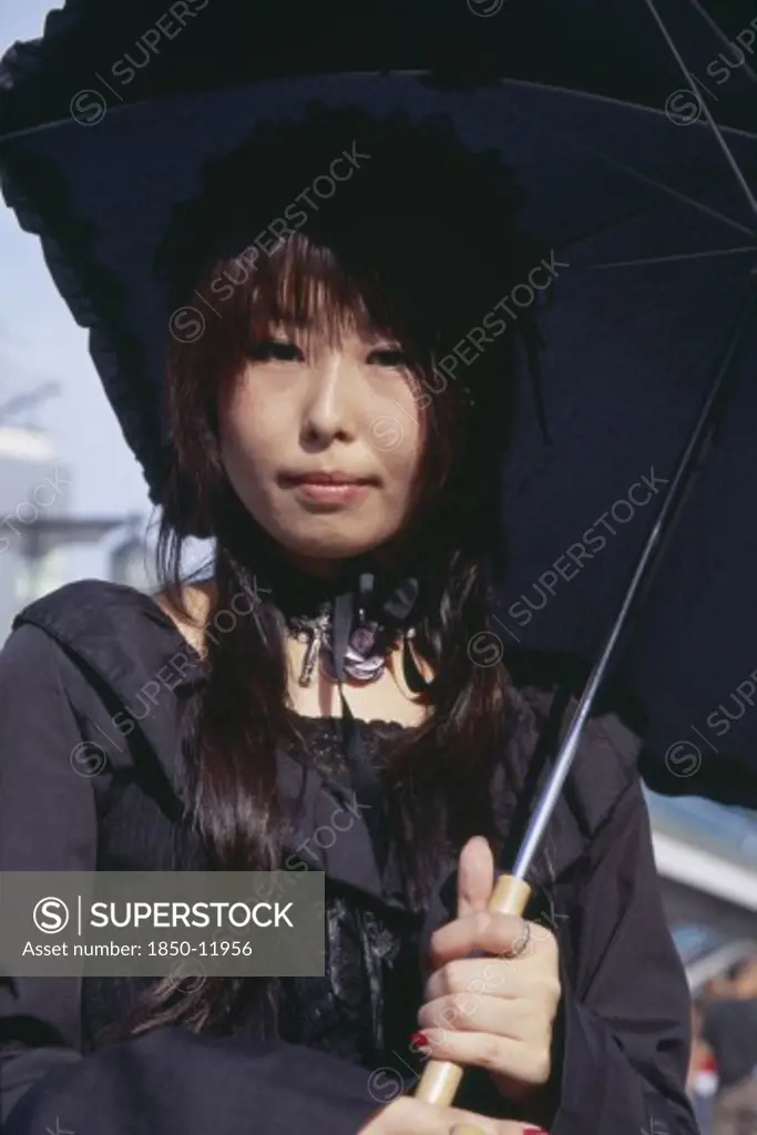 Japan, Honshu, Tokyo, Harajuku District. Portrait Of A Teenage Girl Dressed In Black With A Black Parasol