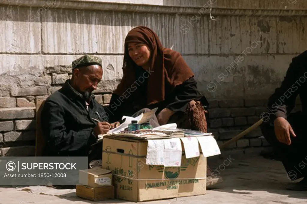 China, Xinjiang, Kashgar, Woman Dictating To Letter Writer At Stall Outside Post Office.