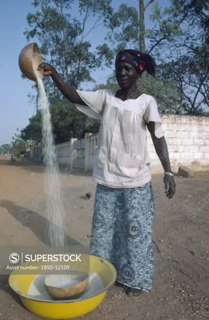 Burkina Faso, Ouagadougou, Woman Winnowing Rice.