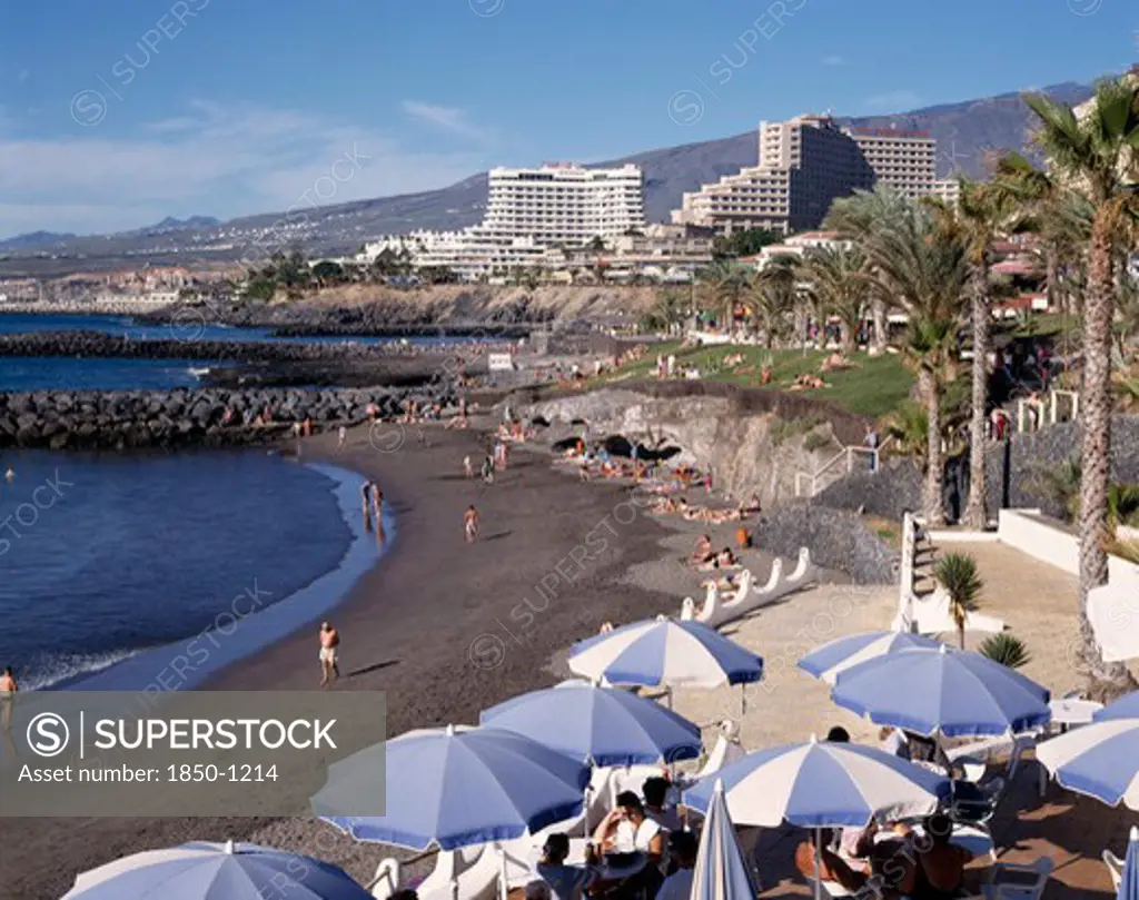 Spain, Canary Islands, Tenerife, Playa De La Americas With Black Sandy Beach And Apartments In The Distance