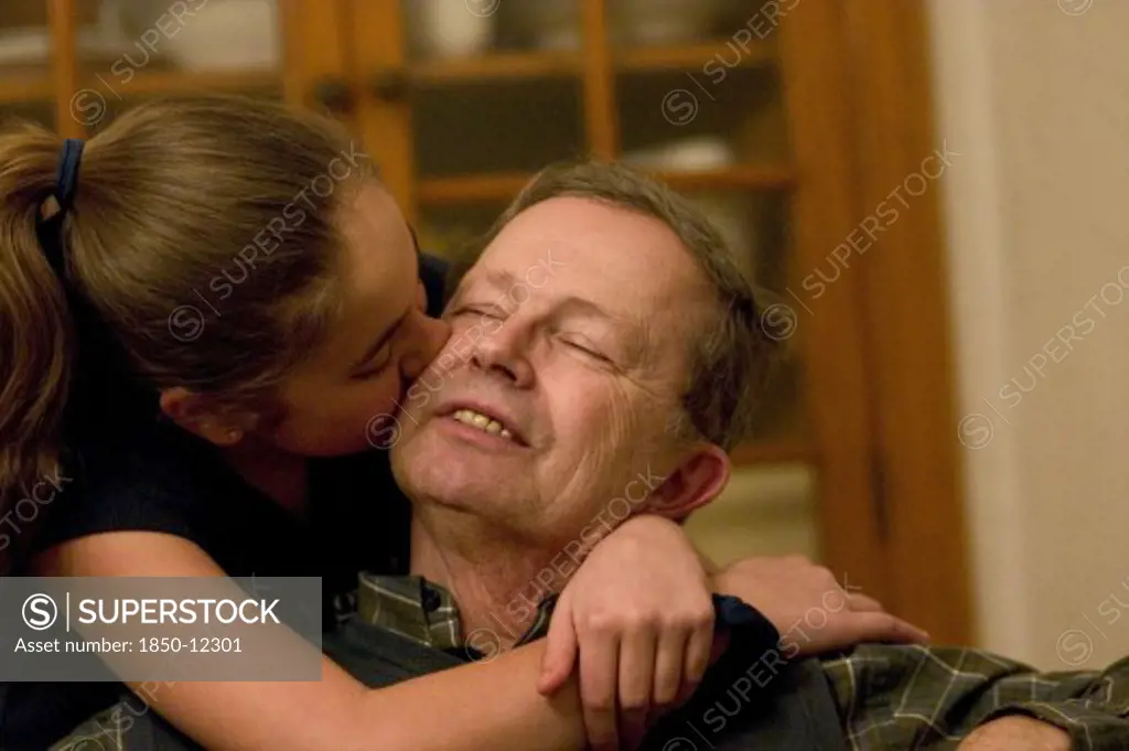 Usa, Minnesota, St Paul, Grandaughter Hugging And Kissing Her Grandfather On The Cheek