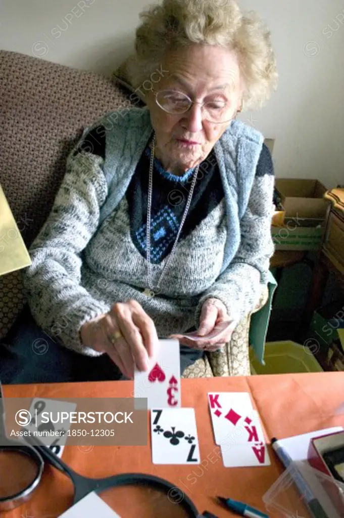 Usa, Minnesota, Edina, Elderly Woman Playing Solitaire Card Game With Large Print Cards.