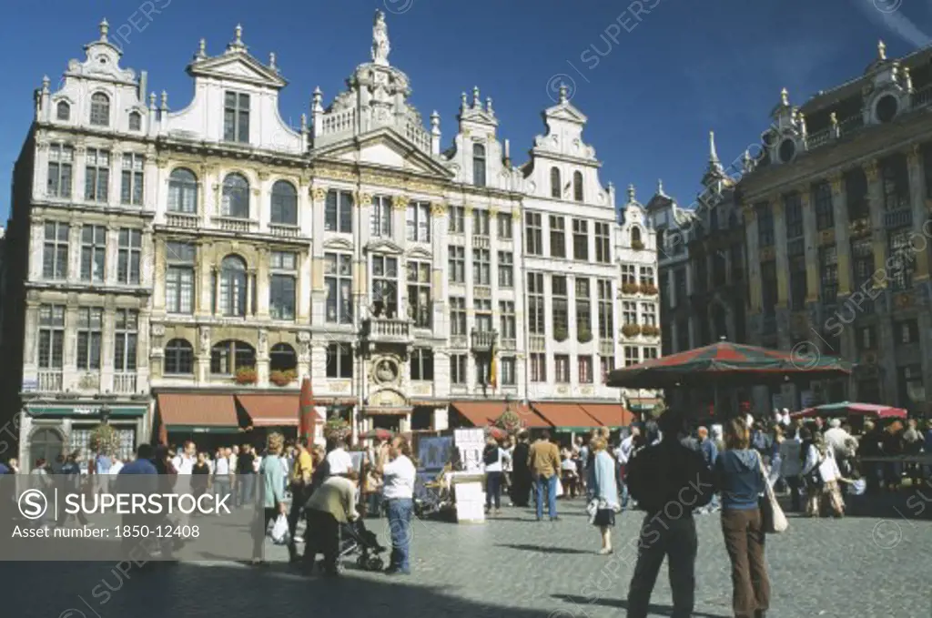 Belgium, Brussels, Grand Place Lined With Cafes With Crowds Of People And Stalls.