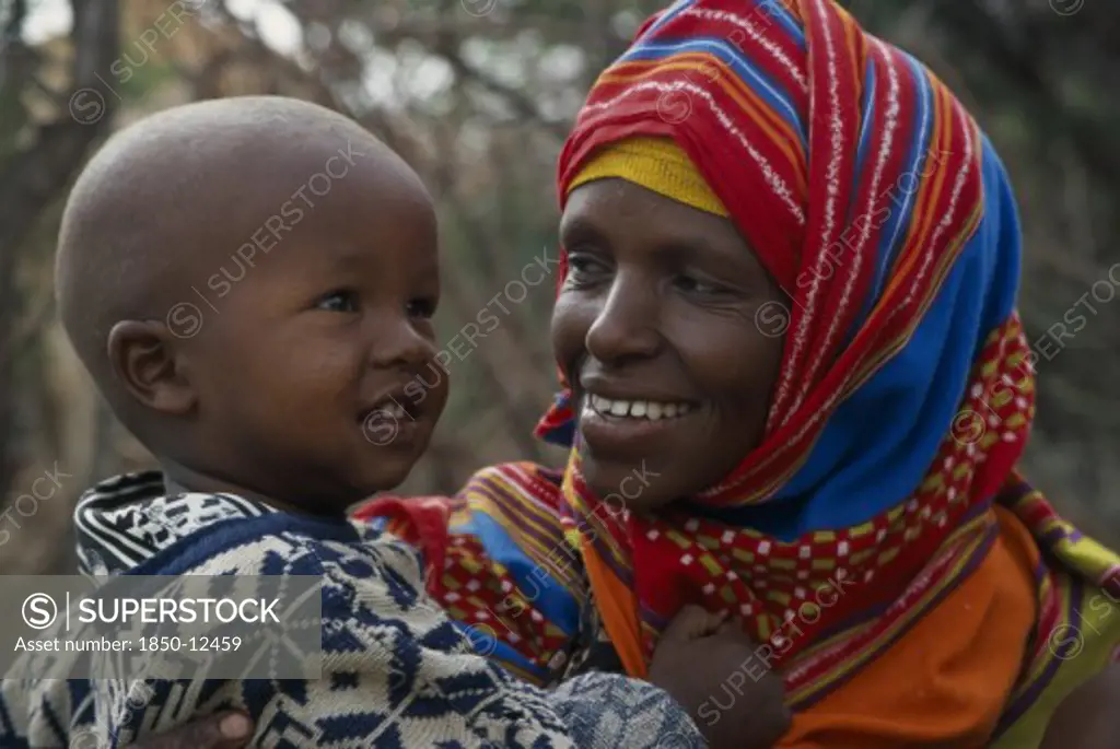 Somalia, Near Hargeisa, Portrait Of Mother Wearing Colourful Headscarf Holding And Looking At Her Child