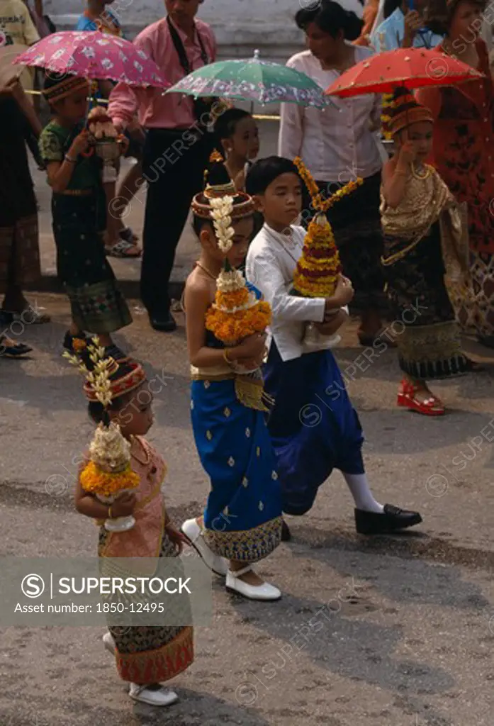 Laos, Luang Prabang, Children In Traditional Dress Carrying Offerings At New Year Celebrations.