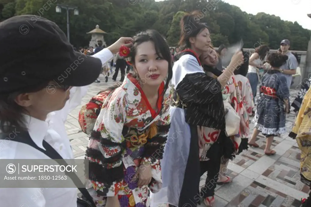 Japan, Honshu, Tokyo, Harajuku. A Member Of The Kyoto Rokumeikan Troupe Has Her Hair Adjusted During A Break From Dancing At The Entrance Of Yoyogi Park Dressed In Half Kimono Costumes On Saturday Afternoon