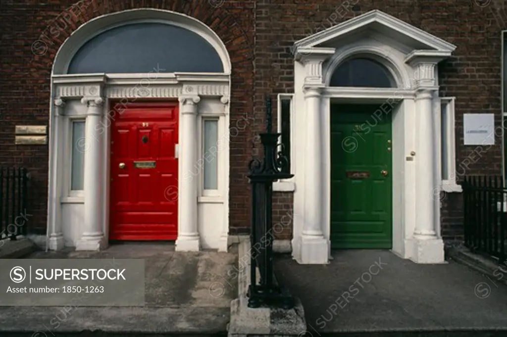 Ireland, Dublin, 'Two Georgian Front Doors, One Red And One Green, Separated By Railings. Both With White Columns And Arches.'