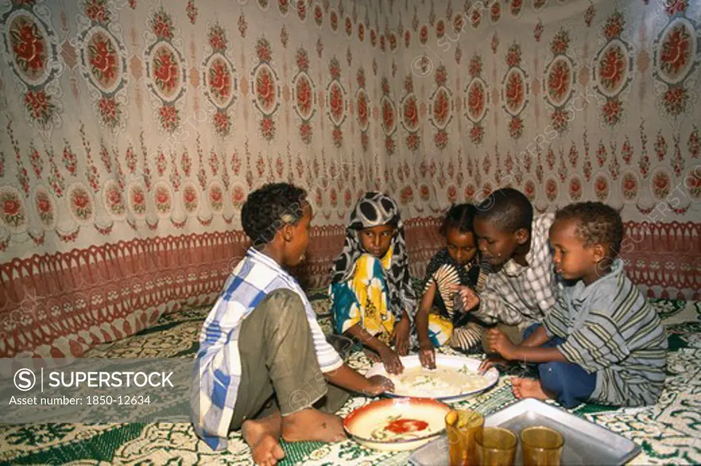 Somalia, Baidoa, Children Eating Meal At Home From Communal Dish Using The Right Hand.  At A Family Meal Men Are Usually Served First And Women And Children Eat Seperately Later.