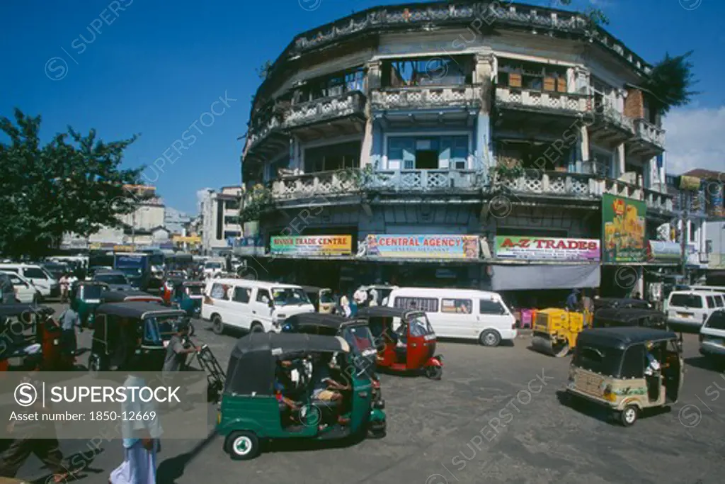 Sri Lanka, Colombo, 'Pettah District. Busy Street Full Of Traffic Including Auto-Rickshaws, Taxis, Minibuses And A Steam Roller.  Advertising Hoardings On Building Behind.'