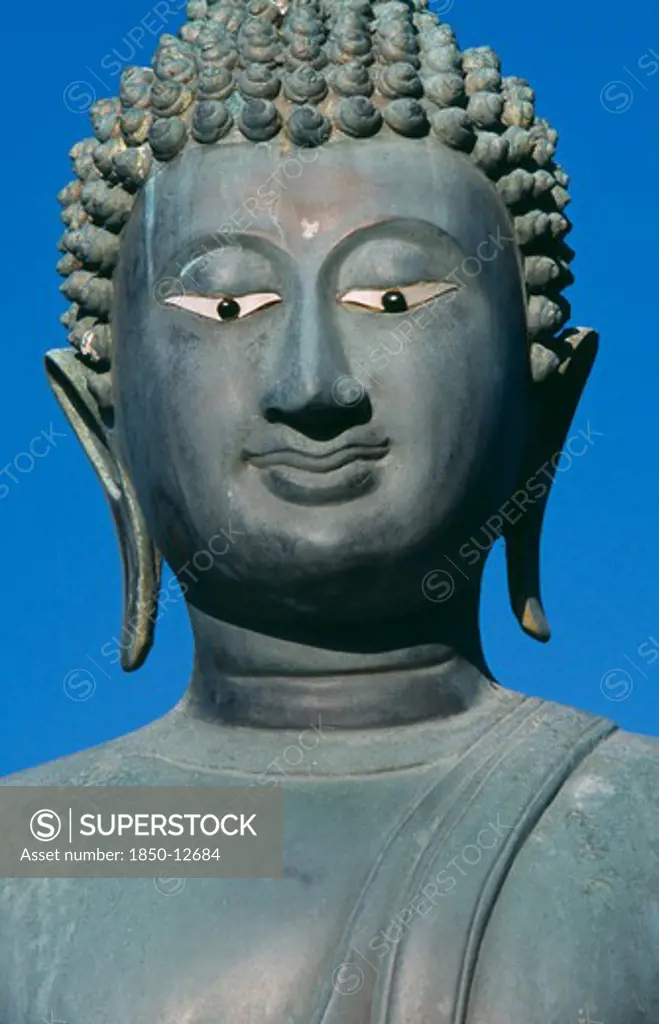 Sri Lanka, Colombo, Seema Malakaya On Beira Lake. Face Of A Buddha Statue Against A Blue Sky