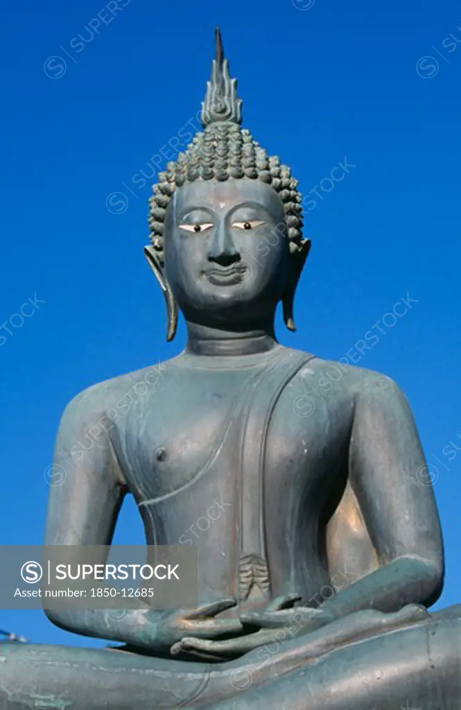 Sri Lanka, Colombo, Seema Malakaya On Beira Lake. Seated Buddha Statue Against A Blue Sky