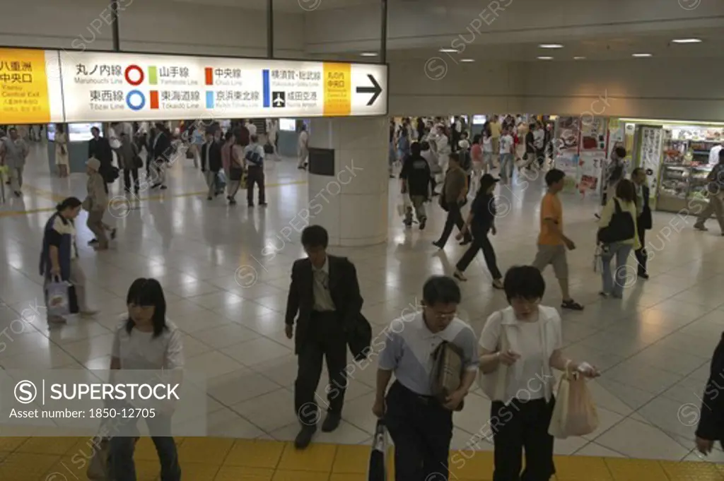 Japan, Tokyo , Tokyo Station Interior With Crowds And Bilingual Color-Coded Signs Above