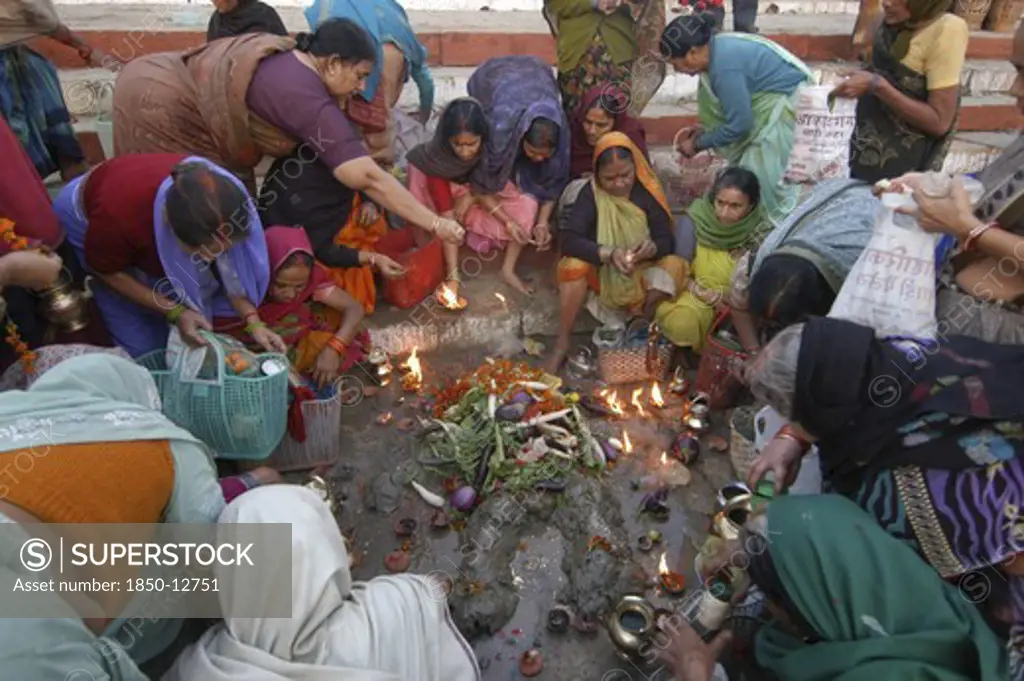 India, Uttar Pradesh, Varanasi , Hindu Women Worship An Earthen Statue Of Hindu God Bhim At Asi Ghat Beside The Ganges River