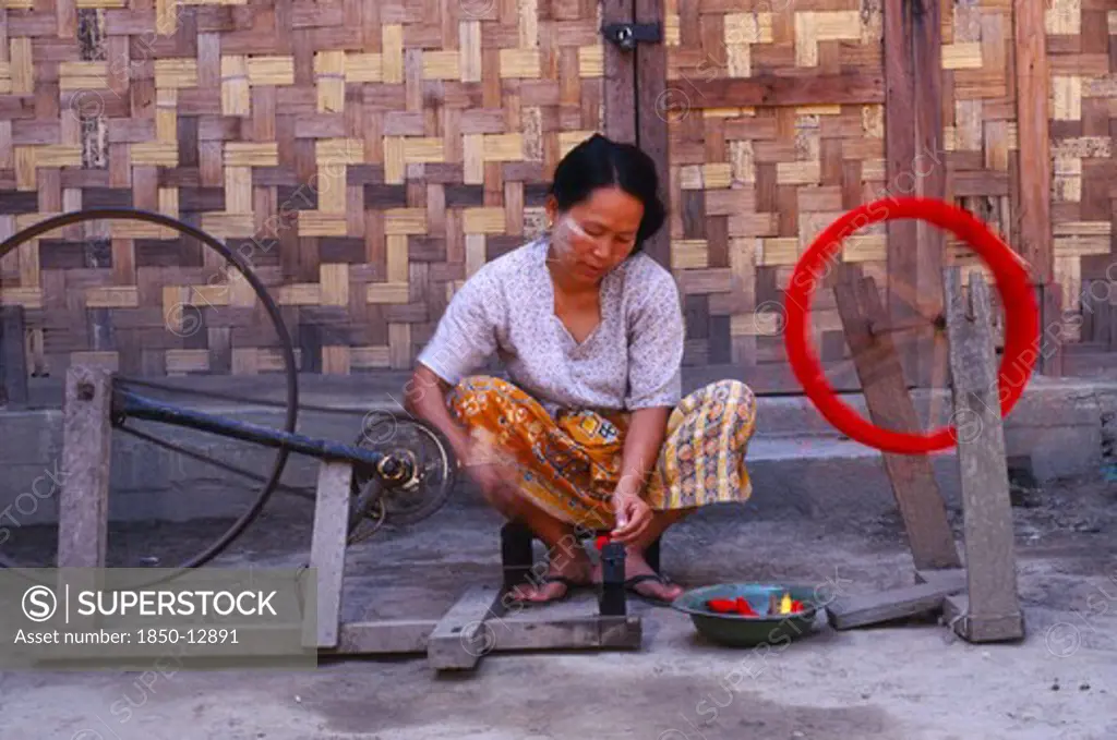 Myanmar, Kachin State, Myitkyina, Jinghpaw Woman Spinning Thread Onto A Bobbin For Weaving At A Weavers Shop