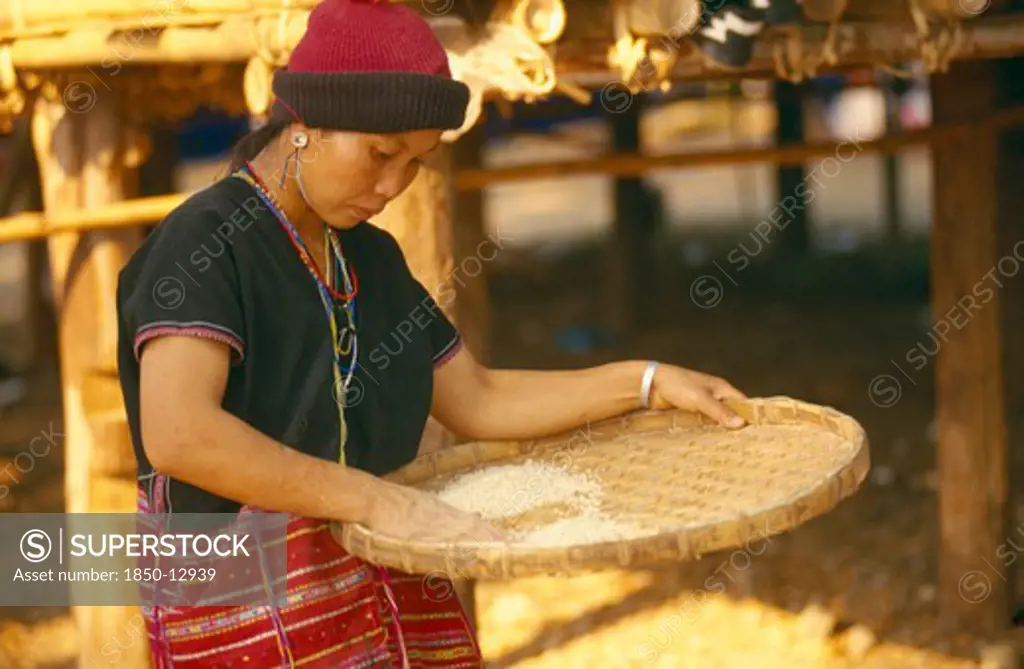 Thailand, Chiang Mai, Sgaw Karen Woman Using A Bamboo Tray To Sift Pounded Rice