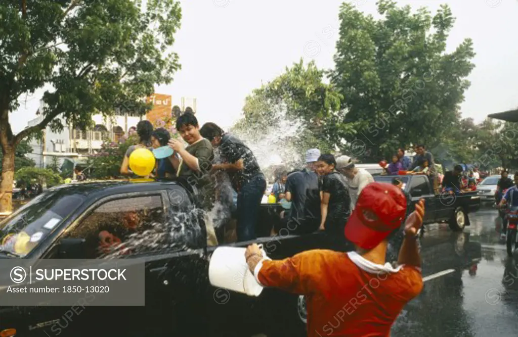 Thailand, Chiang Mai, Songkran Aka Thai New Year. Revellers In A Pickup Truck Attempting To Catch Some Of The Water Thrown At Them