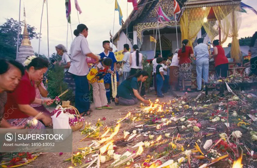 Thailand, Chiang Mai, Wat Jedi Luang, Inthakhin Ceremony. People With Offerings Of Flowers Candles And Joss Sticks