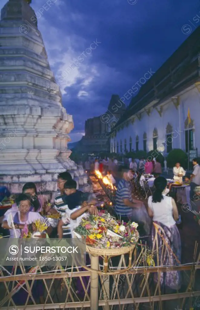 Thailand, Chiang Mai, Wat Jedi Luang, Inthakhin Ceremony. People With Offerings Of Flowers And Joss Sticks Circimambulating
