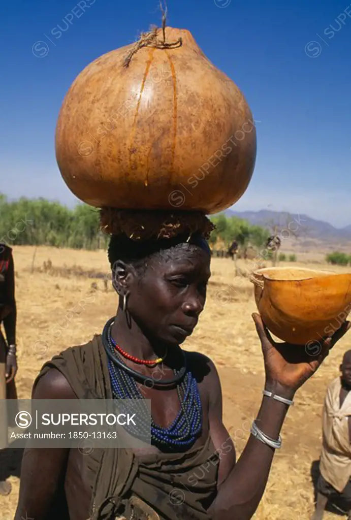 Uganda, Karamoja, Moroto District, Karamojong Woman Carrying Water Gourd On Her Head.