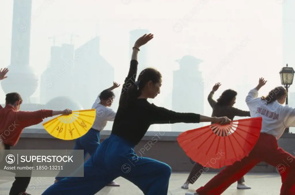 China, Shanghai, Early Morning Group Exercise Using Fans On The Bund.