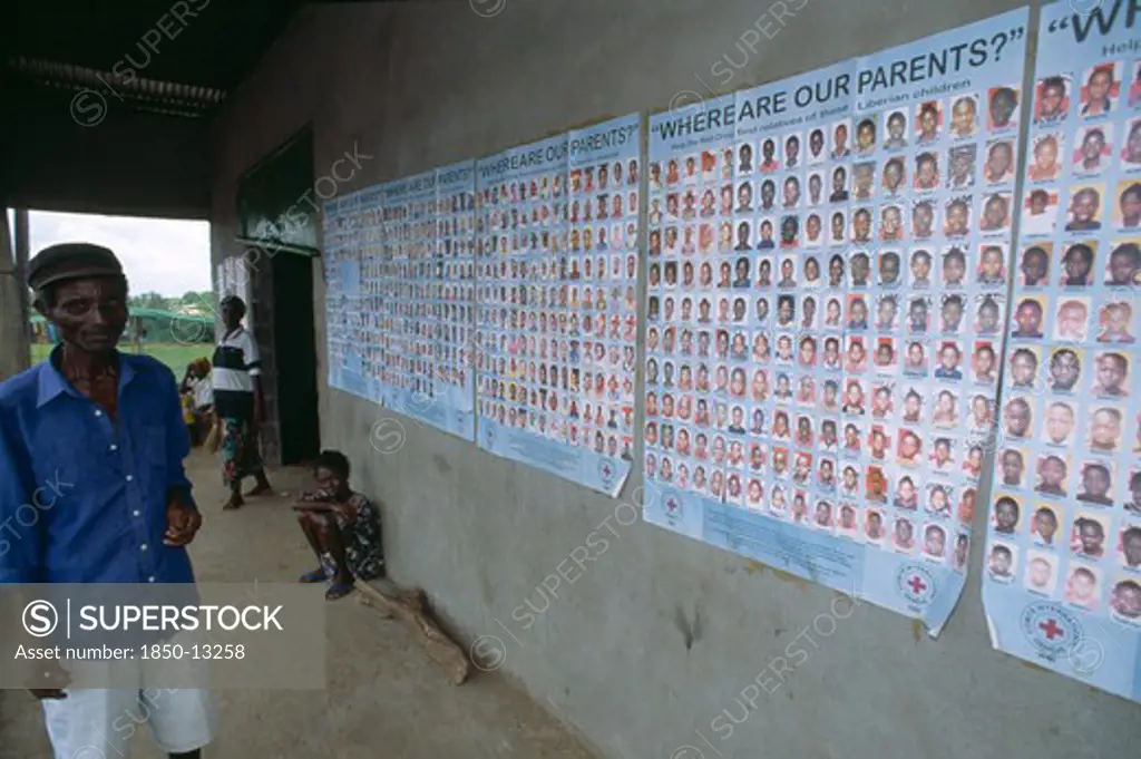 Liberia   , Margibi, Kakata, Man Standing Next To Red Cross Tracing Posters Of Liberian Children Whose Parents Are Missing