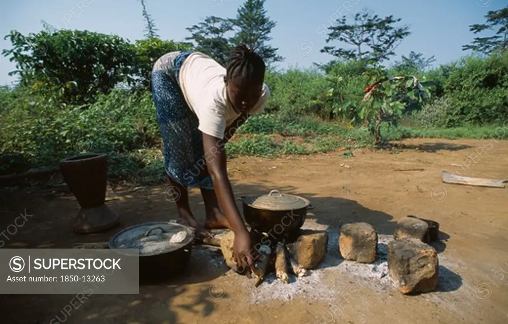 Liberia   , Nimba, Saclepea, Young Woman Cooking On Open Wood Fire.