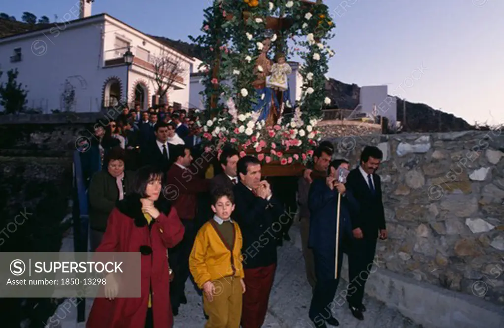 Spain, Andalucia, Festivals, Christmas Procession Through Village Carrying Garlanded Statue Of The Virgin And Child.