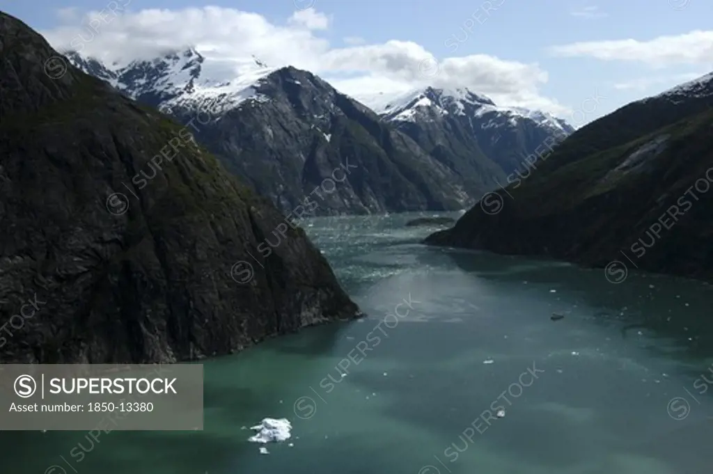 Usa, Alaska, Tracy Arm Fjord, View Over Rocky Cliff Edged Waterway Toward Mountain Peaks