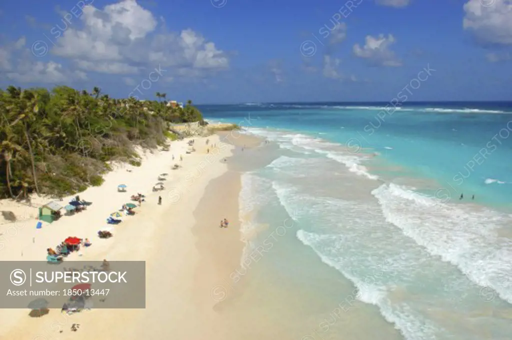 West Indies, Barbados, St Philip, View Along Crane Beach With Scattering Of Umbrellas And Sunbathers
