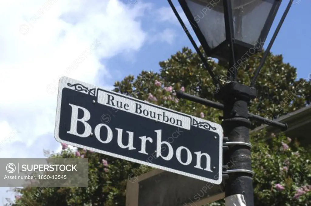 Usa, Louisiana, New Orleans, French Quarter. Rue Bourbon Street Sign Hanging On A Lamp Post